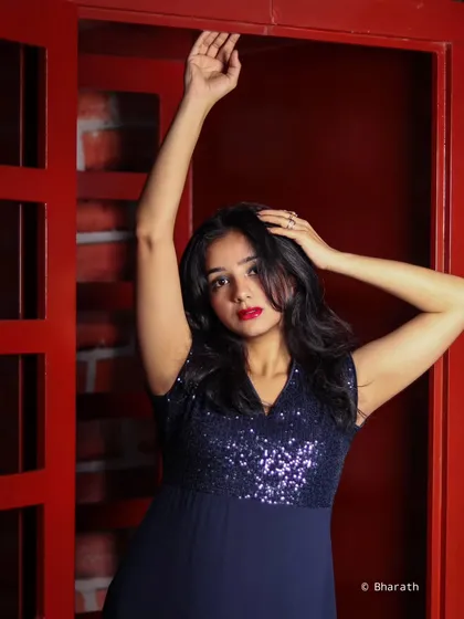A dynamic pose with arms raised, showcasing the flow of the gown and the sparkle of the sequins.