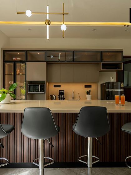 This modern kitchen and bar area is the heart of the home. It features sleek, handleless cabinets, under-cabinet lighting, and a large island with comfortable bar stools, perfect for casual dining and socializing.