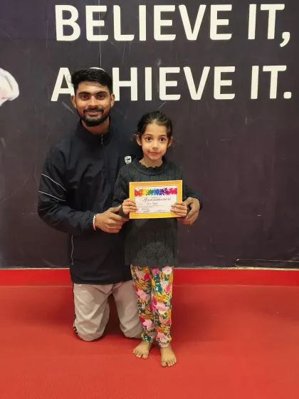This young gymnast is excited to receive her certificate from her coach.