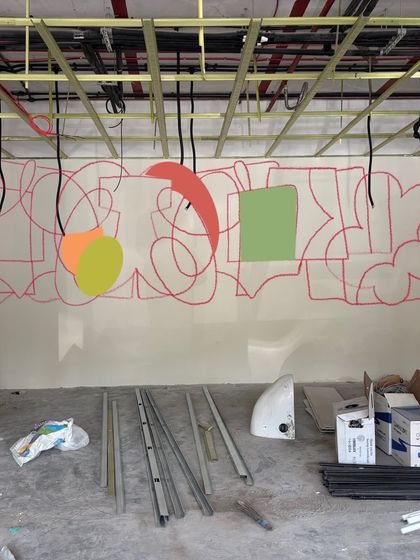 The very beginning of the 42-foot mural. It starts with simple lines and color blocking, a foundational map for the complex and vibrant composition that will emerge.