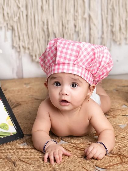 This little chef is melting my heart. The details in this setup, from the gingham hat to the spice rack, create such an adorable and convincing culinary scene.
