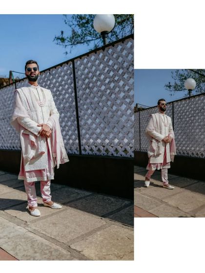A stylish, full-length portrait of the groom in his elegant pastel pink and white wedding attire.