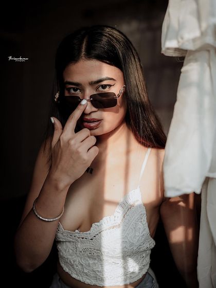 This portrait combines strong shadows with a confident pose, creating a cool and mysterious vibe. It's a great style for a model's portfolio.