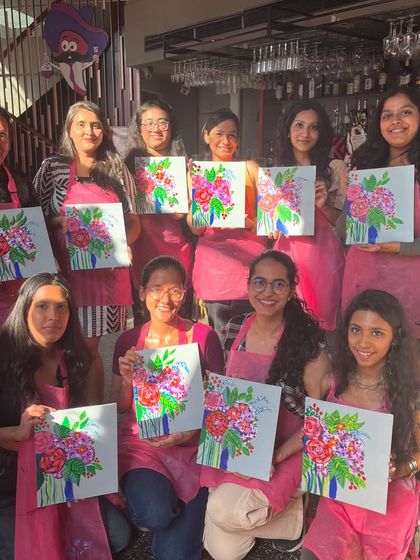 A group showing off their lovely floral bouquet paintings at a cafe workshop. The bright colors and cheerful subject made for a very happy session.