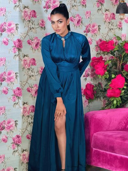 A full-length shot of the teal gown and the sleek high ponytail.