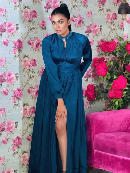 A full-length shot of the teal gown and the sleek high ponytail.