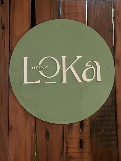 The Rising Loka sign on our wooden fence. A simple symbol of the warm, natural, and welcoming space we've created.