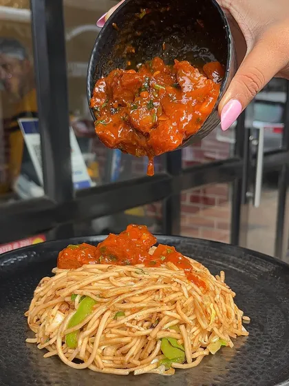 Pouring the delicious sauce over my Chaupal Noodles. This dish is all about the perfect balance of flavours.