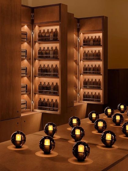 An array of Bocci 14p lamps arranged on a counter in a dark, moody room, creating a striking pattern of light.