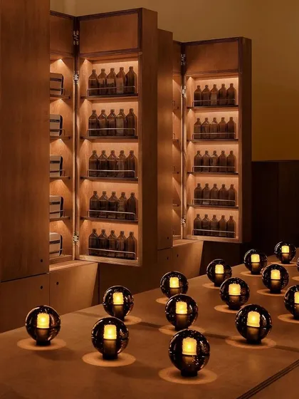 An array of Bocci 14p lamps arranged on a counter in a dark, moody room, creating a striking pattern of light.
