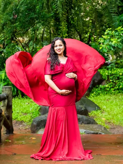 Making a statement in red. The wind catches the fabric of this beautiful gown, creating a dramatic and powerful image of motherhood.