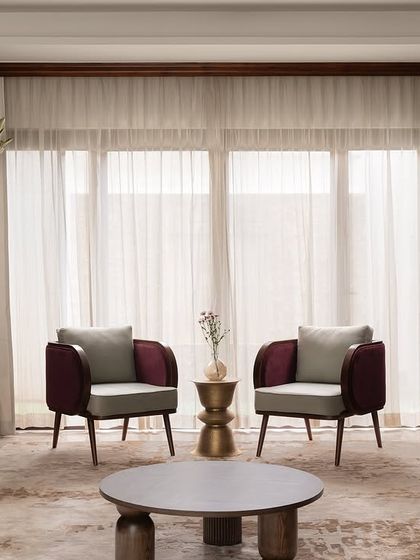 A full view of the formal living room at our Tinted Tapestries project. We paired custom-designed magenta velvet sofas with two-toned armchairs and sculptural brass side tables to create a space that is rich in color, texture, and modern elegance.