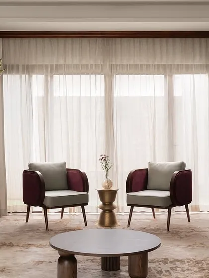 A full view of the formal living room at our Tinted Tapestries project. We paired custom-designed magenta velvet sofas with two-toned armchairs and sculptural brass side tables to create a space that is rich in color, texture, and modern elegance.