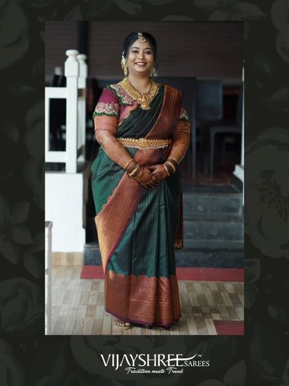 A full-length view of our client's green and rust Kanjivaram, showcasing the rich colors and elegant drape.