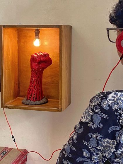 A visitor engages with the "Orma Petti" installation, listening to the narrated memory associated with the sculpture. Our space encourages interactive and deeply personal art experiences.