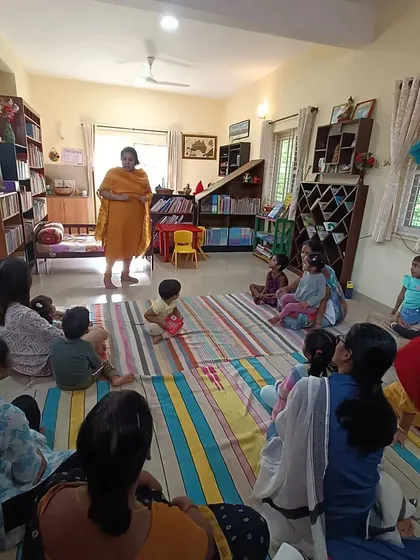 A wide view of a story about an elephant, with the storyteller using her body to mimic the animal's trunk.
