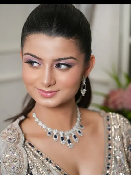 A portrait of the model, highlighting her makeup and the beautiful blue stone necklace.