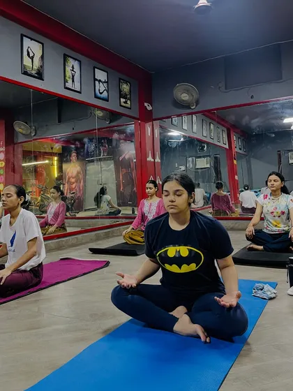 Students in a seated meditation pose, finding their center. My sessions are suitable for all levels, even for those who have never tried yoga before.