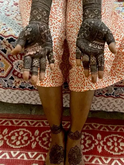 This image captures the beauty of a full bridal mehendi set, with intricate patterns on both hands and simpler, elegant designs on the feet.