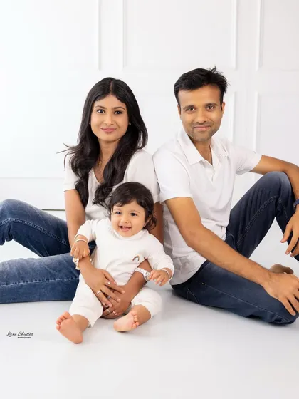 A relaxed, seated family portrait. We coordinate outfits and use a clean, white background to create a cohesive and modern look for your family photos.