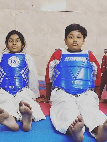 A moment of rest between rounds. Sparring is intense, and these students show the focus and composure needed to succeed in a competitive setting.