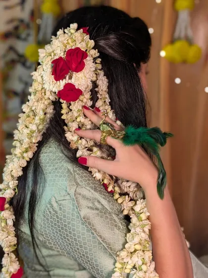 A close up of the stunning mogra and rose hairstyle created for this Haldi look. The fragrance and beauty of fresh flowers add an unmatched charm.