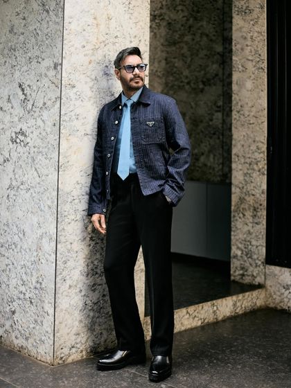 A three-quarter shot against a marble wall, emphasizing the sharp, contemporary feel of the outfit.