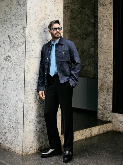 A three-quarter shot against a marble wall, emphasizing the sharp, contemporary feel of the outfit.