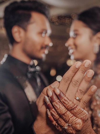 A close-up shot focusing on the couple's hands and the engagement ring, a symbol of their commitment.