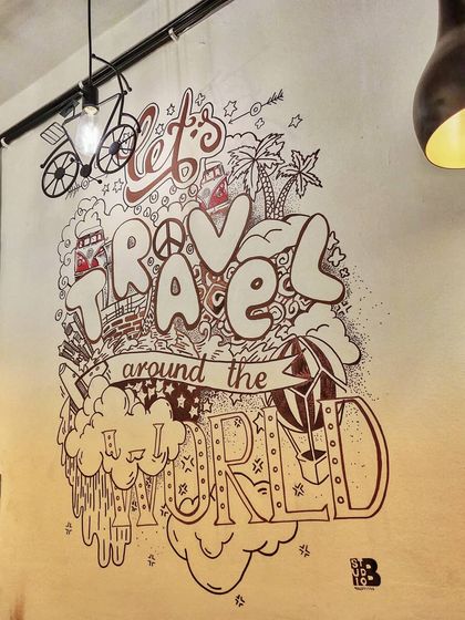 A detailed shot of the "Let's Travel" doodle. We use permanent markers for crisp lines and intricate details in our black and white murals.