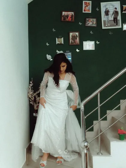 The bride's descent down the stairs, a classic and timeless wedding moment captured in her home before the ceremony begins.