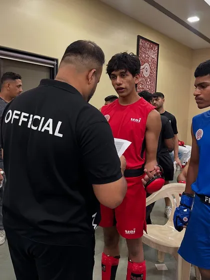 In my role as an official, giving instructions to fighters before their bout. My experience as a referee gives me a unique perspective that benefits my own fighters' training.