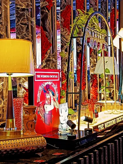 A close-up of the detailed decor on one of my bar setups. It features a retro lamp, tiki glasses, and custom branded menus, all contributing to a cohesive theme.