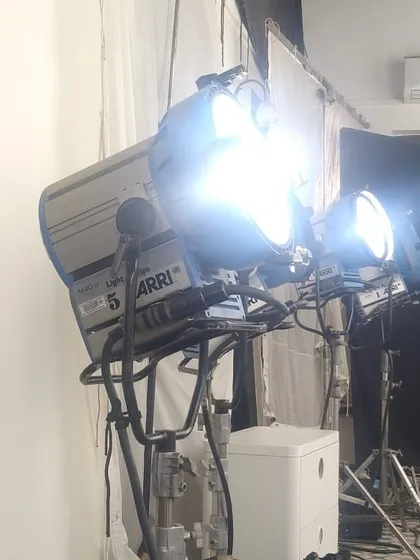 An Arri M40 HMI fixture, a powerful daylight source, is bounced off a large muslin cloth. This technique, known as a book light, creates an extremely soft and flattering quality of light, perfect for commercial and beauty work.