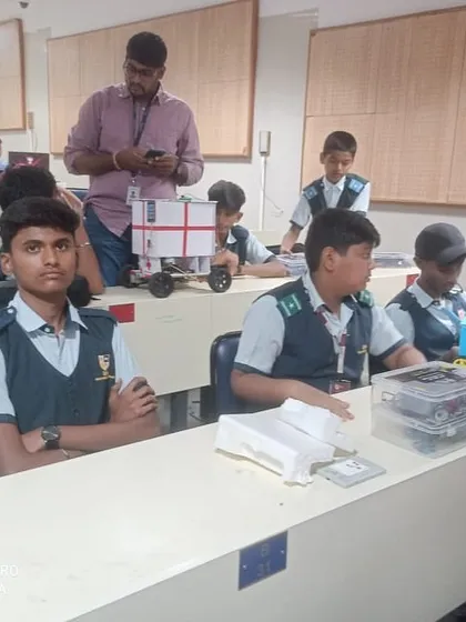 Participants in a classroom setting with their custom-built robots, preparing for the competition rounds at our IIT Bombay event.