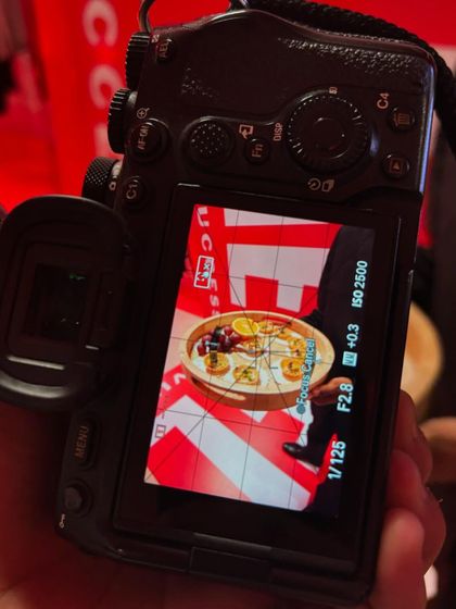 A behind-the-scenes shot of a canapé platter being photographed against the bold red branding of the Diesel event. Every detail is captured to tell the story of the collaboration.