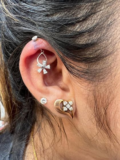 A delicate look with a floral hanging and a leaf-shaped gold lobe stud.