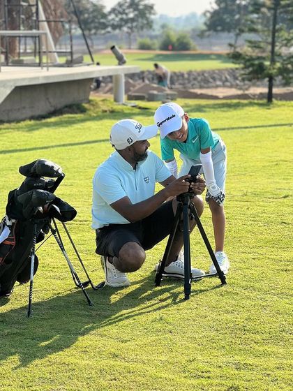 A coach and a junior player review a video of his swing. We empower players with knowledge, rather than just instructing them.