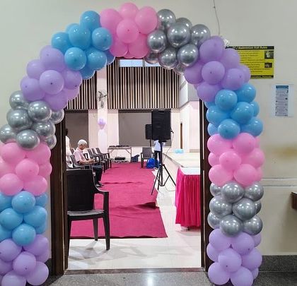 A colorful balloon arch in pastel shades of pink, purple, blue, and silver for a Frozen-themed first birthday, showing my ability to execute themed parties for family events at corporate venues.
