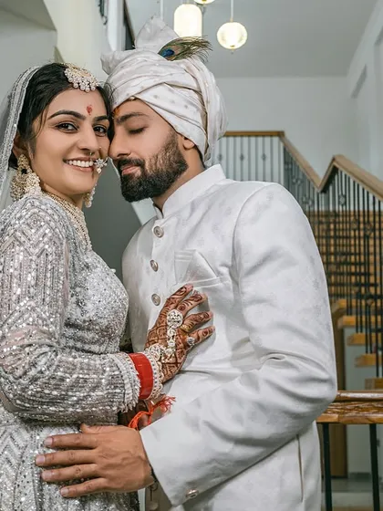 Joined together in love. A candid, happy moment shared between the couple on a staircase, away from the crowd.