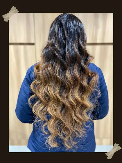 This is the sunkissed look everyone dreams of. We created this beautiful balayage on long hair, blending dark roots seamlessly into warm, golden ends and finishing with soft waves to show off the dimension. This is a perfect example of our custom hair highlighting services.