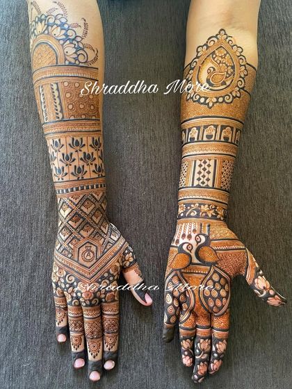 A lovely bridal design with a mix of geometric patterns and traditional motifs. The peacocks and lotuses are beautifully detailed, creating a balanced and elegant look.