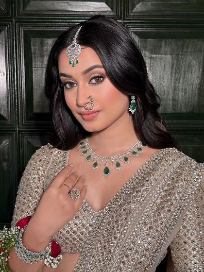 A confident and direct gaze. The eye makeup here is the focus, with a soft wing and warm brown tones that make her eyes pop. The skin is kept luminous and fresh.