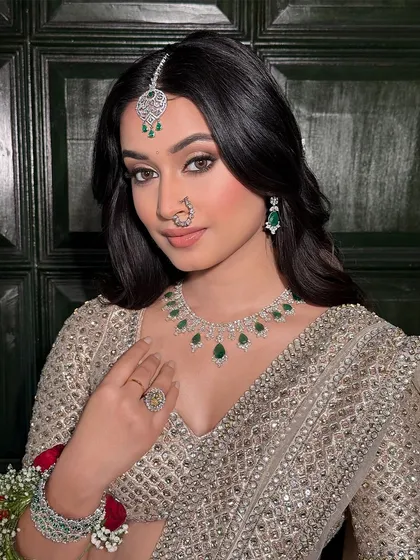 A confident and direct gaze. The eye makeup here is the focus, with a soft wing and warm brown tones that make her eyes pop. The skin is kept luminous and fresh.