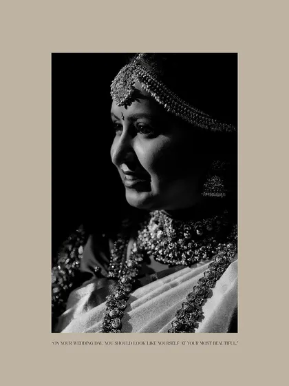 A classic black and white profile shot of the bride. The high-contrast lighting beautifully sculpts her features and highlights her intricate jewelry.