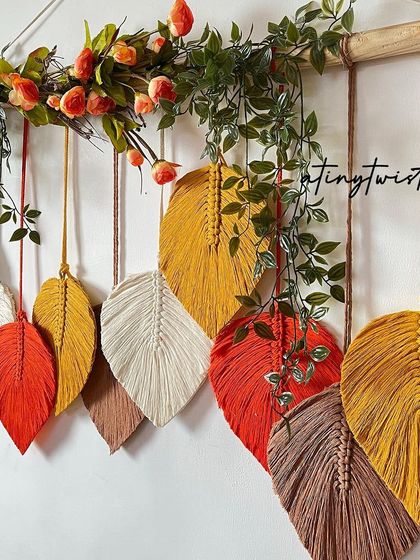 A close-up of this vibrant, autumn-inspired leaf wall hanging. The mix of red, orange, yellow, and brown tones creates such a warm and inviting piece of art.