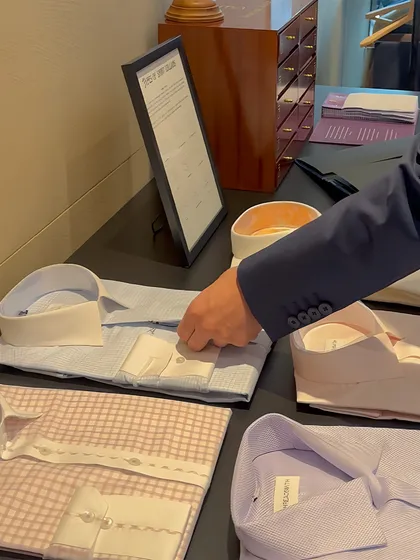 An executive at our Khaitan trunk show examines our selection of custom shirts. We believe true elegance isn't bought; it's meticulously crafted.