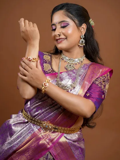 The bride's pose highlights the beautiful details of the long necklace and the matching bracelets.
