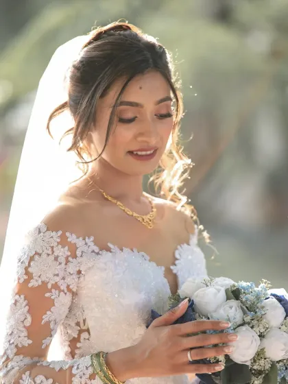 A classic bridal portrait with a touch of magic. The soft backlighting highlights the delicate details of her dress and veil, creating a dreamy, ethereal look.