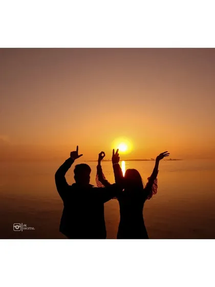 A fun and celebratory silhouette of the couple against the setting sun. It's a perfect way to capture the joy and excitement of their journey together.